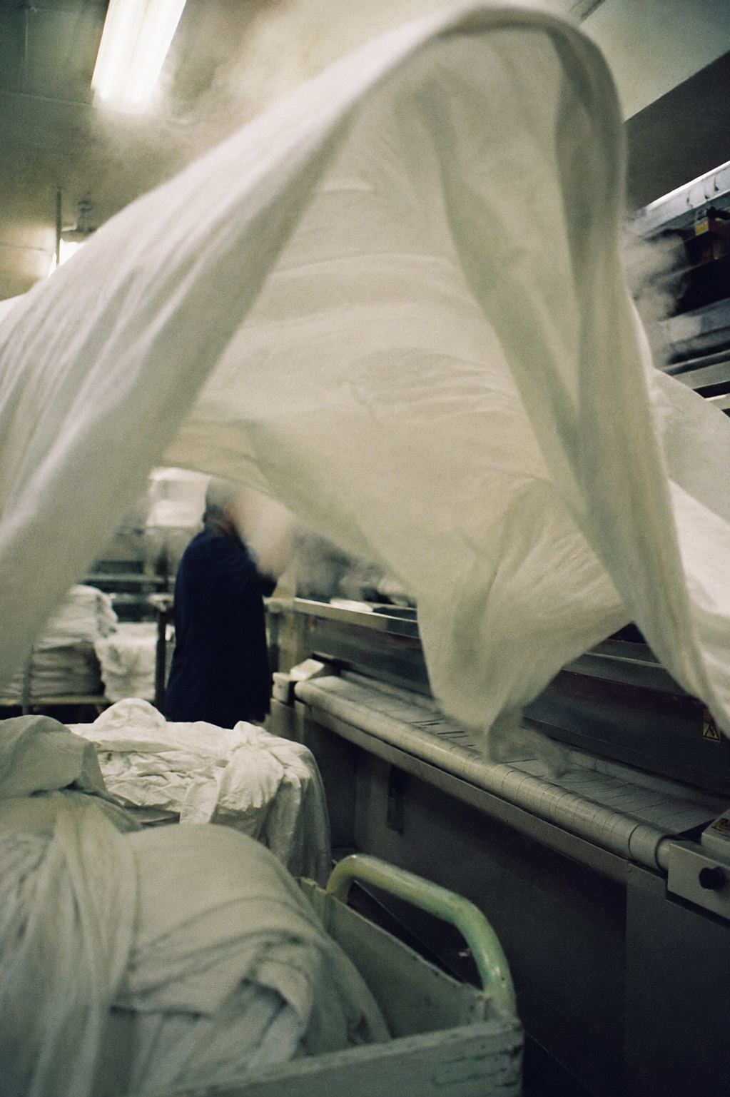 A sheet flying over the press in a commercial laundry